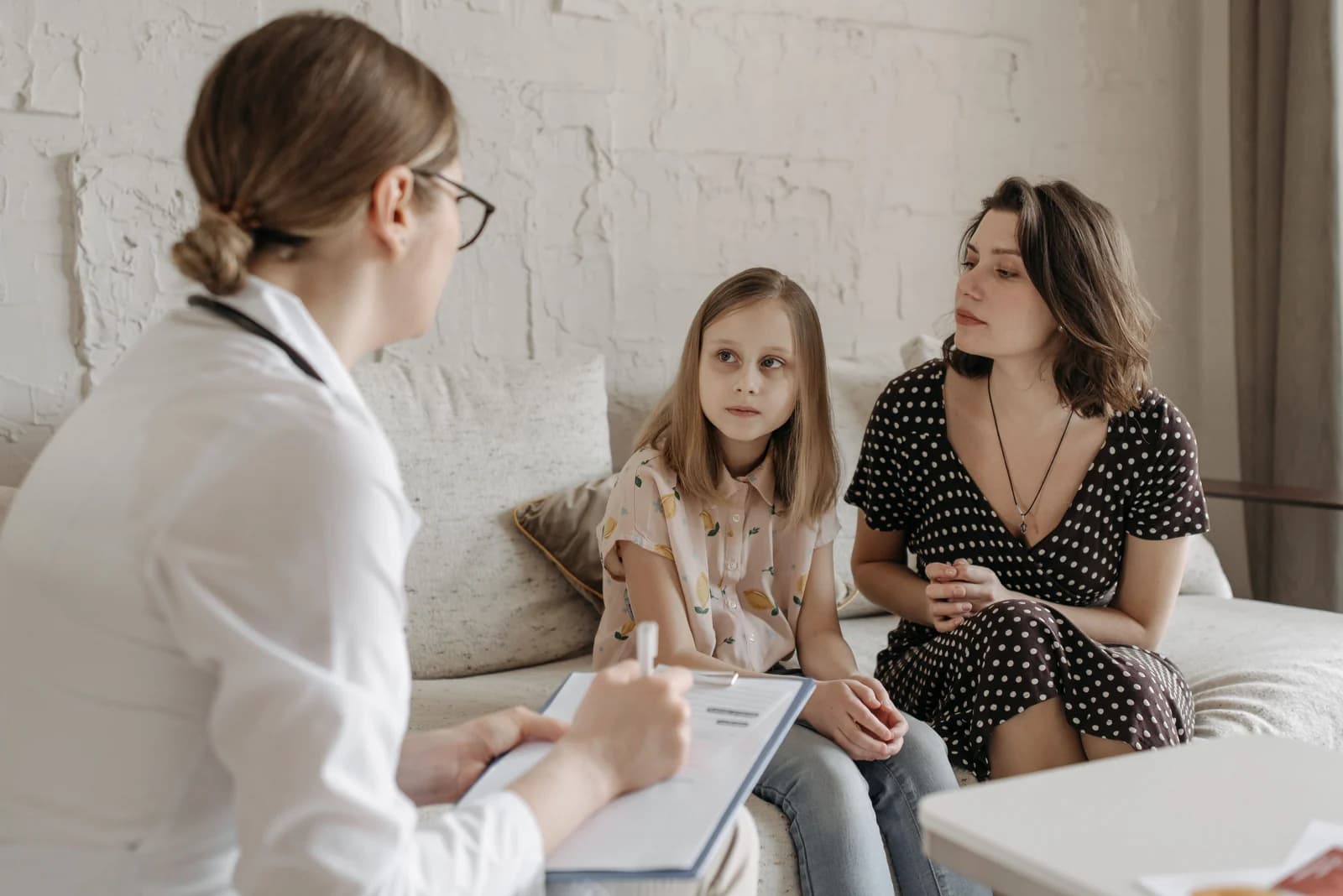A clinician talking with a mother and daughter